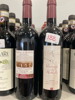 plusieurs bouteilles de vin sont alignées sur une étagère