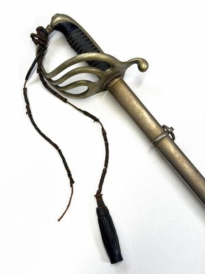 une épée en métal avec une poignée noire sur un fond blanc