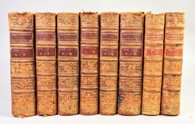 plusieurs vieux livres sont alignés sur une surface blanche