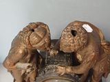 two figurines that are sitting on top of a clock