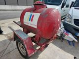 a red propanent on a trailer with a white van in the background