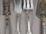 five silver spoons and a fork on a table