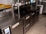 une cuisine avec de nombreux plans de travail en inox