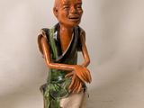 pair of asian figurines of a man sitting on a rock