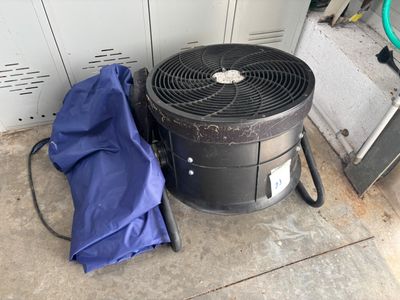 un parapluie bleu posé à côté d'un climatiseur noir