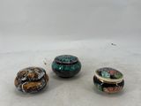 three different colored glass beads sitting on top of a white surface