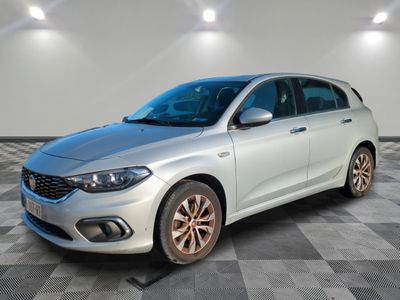 la voiture blanche est garée dans une pièce au sol en damier
