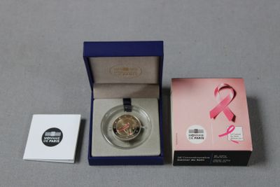 un ruban rose dans une boîte à côté d'un ruban rose