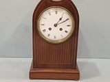 une petite horloge en bois à laquelle est attachée une clé