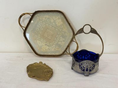 un plateau en argent et un saladier en verre bleu posés sur une table
