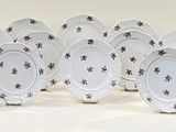 nine plates with black flowers on them on a white surface