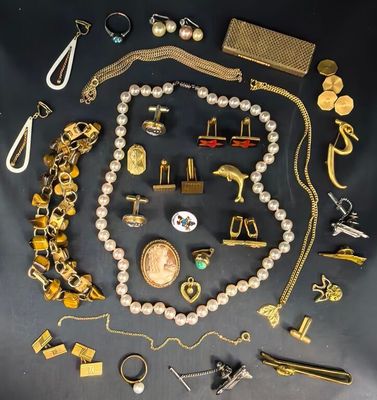 de nombreux bijoux en or et en argent posés sur une table noire