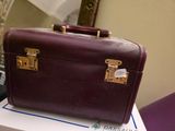 une valise violette posée sur une boîte blanche