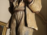 a statue of a boy that is holding a banana