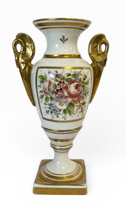 un vase blanc orné d'une anse dorée et de motifs floraux