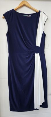 une robe bleue et blanche suspendue à un cintre devant un mur blanc