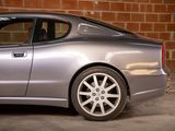 a silver car parked in front of a brick wall