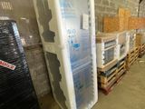 a refrigerator that is sitting in a warehouse next to pallets