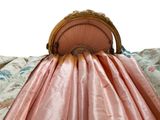 a bed with a pink bed cover and a pink chair