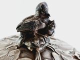 a silver box with a bird sitting on top of it