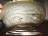 a person holding a glass bowl with a design on it
