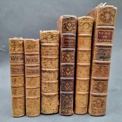 several old books stacked on top of each other on a table