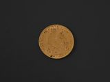 a close up of a gold coin on a black surface