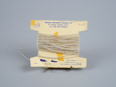 une vieille bobine de fil sur laquelle est posée une aiguille