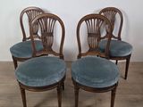 four chairs with blue velvet upholstered seats in a room