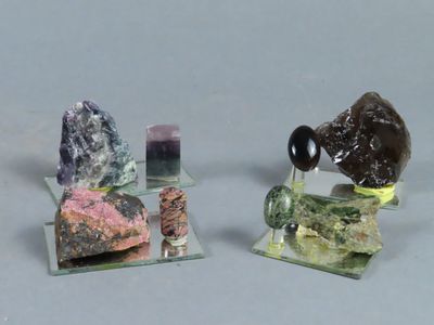 trois types différents de roches et de cristaux posés sur un socle en verre
