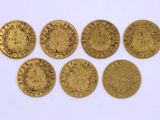 un groupe de cinq pièces d'or posées sur une surface blanche