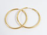 two pairs of gold hoop earrings on a white background