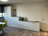a kitchen with a table and green chairs in it
