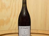 une bouteille de vin posée sur un tonneau en bois