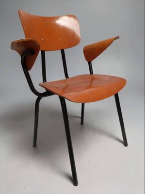 an orange chair with black legs on a white background