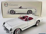 a white toy car with a red top in front of a box