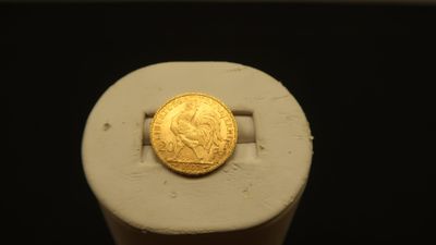 a gold coin sitting on top of a piece of paper