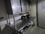 dimly lit commercial kitchen with stainless steel counter tops and stainless steel cabinets