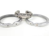 two silver rings with a crown on top of them on a white surface