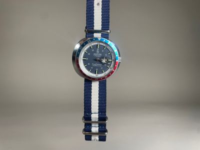 une photo d'une montre avec un bracelet à rayures bleues et blanches