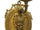 plaque en laiton sur laquelle figurent une tête d'homme et une bougie