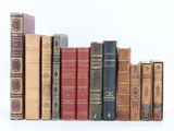 plusieurs vieux livres sont alignés sur une surface blanche