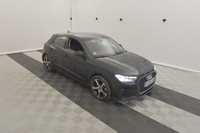 L'Audi QX est garée dans un garage dont le sol est en damier.