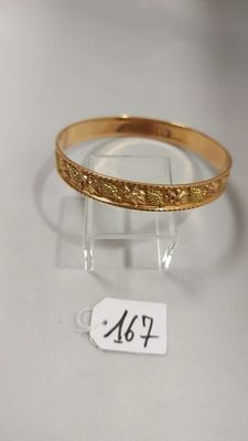 gros plan d'un bracelet en or portant une étiquette de prix