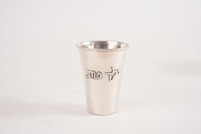 un verre à shot argenté portant une inscription sur un fond blanc