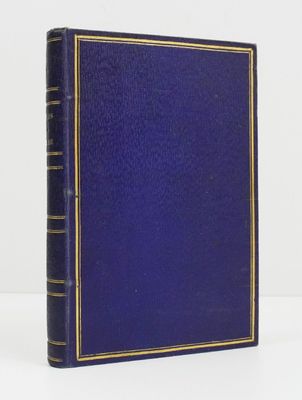 un vieux livre bleu posé sur une table à côté d'un mur blanc