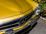 a close up of a yellow car parked in a parking lot