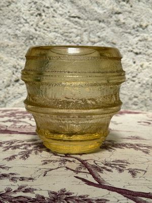 a yellow glass bowl sitting on a table with a purple table cloth