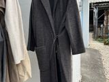 two coats hanging on a clothes rack outside of a building