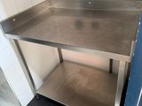 a stainless steel table in a kitchen with a black and white checkered floor
